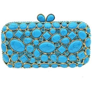 Dettaglio di pietre turchesi e strass brillanti su pochette da sera con cornice dorata
