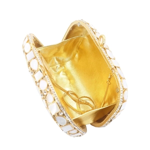 Detailed interior of shell clutch bag with gold lining, diamond crystals and metal chain