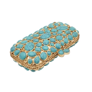 Dettaglio di pietre turchesi e cristalli su una pochette da sera dorata vintage