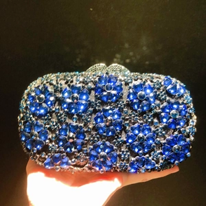 Elegant silver metal clutch bag featuring blue crystal heart and flower patterns