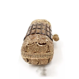 Luxurious cylinder evening clutch bag with golden rhinestones and amber gemstone accents