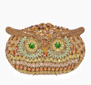 Detailed close-up of owl evening clutch bag with golden rhinestones and green jewel eyes