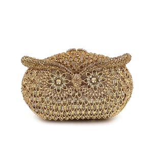Close-up of golden owl clutch bag featuring intricate crystal rhinestones and floral gem eyes