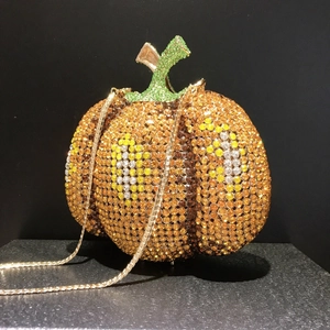 Dettaglio borsa a zucca con strass arancioni brillanti e catena dorata sottile