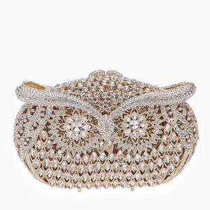 Close-up of owl evening clutch bag with sparkling crystals and golden metal frame