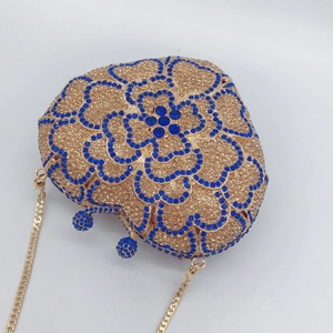 Detail of heart-shaped luxury clutch with champagne and blue rhinestones and gold chain