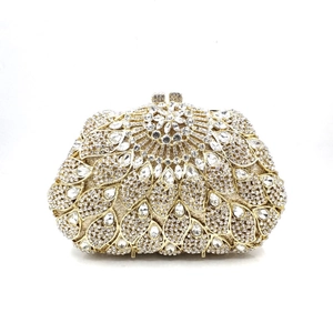 Détail d'une pochette de soirée dorée avec motifs floraux en strass et fermoirs sphériques