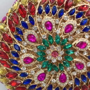 Close-up of luxury evening bag with colorful crystals and gold floral metal base