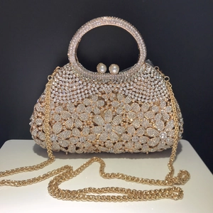 Luxury rhinestone evening clutch with floral patterns, pearl clasp, and gold round handle