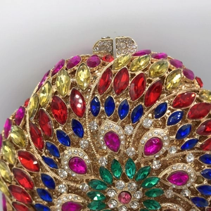Close-up of luxury evening clutch with colorful rhinestones in flower peacock pattern