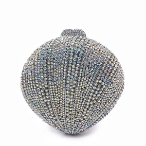 Détail de la pochette en forme de coquillage avec strass irisés et fermoir métallique