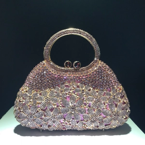 Detailed close-up of crystal evening bag with purple rhinestone flowers and gold handle