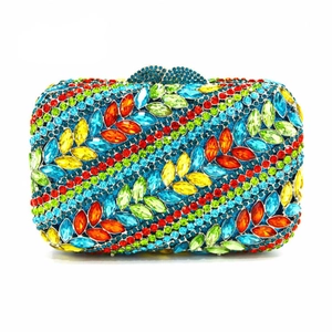 Close-up of luxury floral clutch featuring vibrant multi-colored crystals and bow clasp