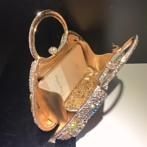 Detail of gold evening bag showing crystal floral patterns and interior storage space