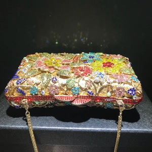 Macro shot of colorful crystal floral patterns and golden frame on the luxury clutch
