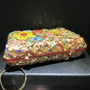 Macro shot of luxury evening clutch with colorful floral crystals and gold hardware