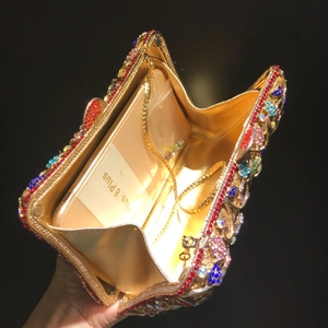 Detail view of the gold diamond flower clutch interior with detachable chain strap