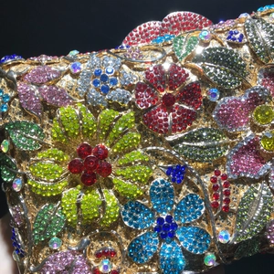 Macro shot of colorful floral rhinestones and gold metal base on luxury clutch bag