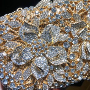 Gros plan de la pochette de soirée dorée avec motif floral et détails en cristal de luxe