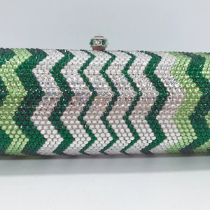 Close-up of green and white rhinestone patterns on a luxury evening cylinder clutch bag