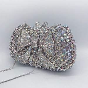 Detail of luxury metal clutch bag featuring colorful rhinestones and bow design