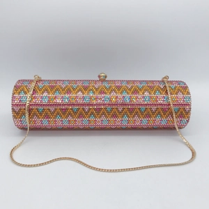 Detailed macro view of colorful rhinestone wave patterns on a luxury cylinder evening clutch bag