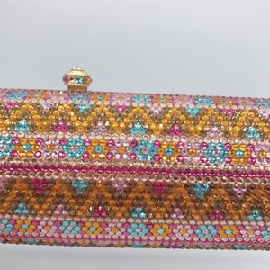 Close-up of luxury evening bag featuring floral rhinestone patterns and metal push-lock