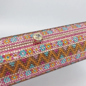 Macro detail of luxury dinner clutch featuring handmade colorful rhinestones and gold clasp