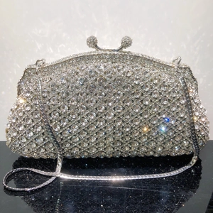 Détail de la pochette de soirée argentée avec strass denses et fermoir à boule élégant