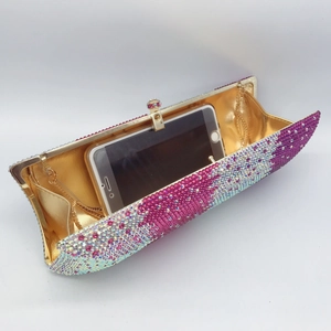 Detailed interior of a pink rhinestone evening clutch with gold chain and metal frame