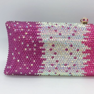 Macro shot of hand-set purple rhinestone gradient and gemstone clasp on luxury evening clutch