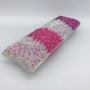 Macro detail of handmade crystal clutch showing magenta and AB rhinestones on gold frame