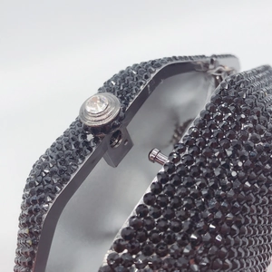 Macro view of luxurious black rhinestone evening bag with silver-tone clasp and diamond detail