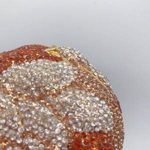 Detailed close-up of sparkling crystals on a golden lion-shaped luxury evening bag
