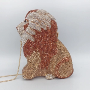 Macro detail of lion head evening bag showing amber rhinestones and gold chain strap