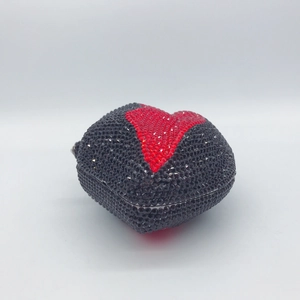 Detailed view of heart-shaped evening bag with full black and red rhinestone encrusting
