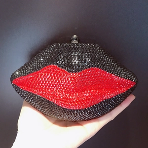 Close-up of red and black crystals on a lip-shaped evening clutch with metal clasp