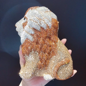 Detailed close-up of a luxury lion-shaped evening clutch bag with sparkling crystals