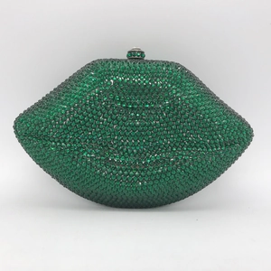 Macro view of luxurious green crystal-encrusted lip-shaped evening clutch with metal frame