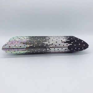 Detailed macro view of gradient rhinestones on a slim evening clutch bag surface