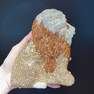 Close-up of a sparkling crystal lion shaped evening clutch bag with intricate gold stonework