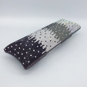 Macro detail of luxury rectangular evening clutch with gradient black and silver rhinestones