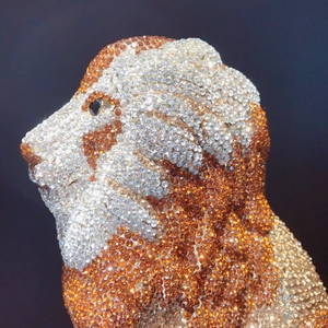 Detailed close-up of lion head evening bag featuring luxury crystal-studded metal surface
