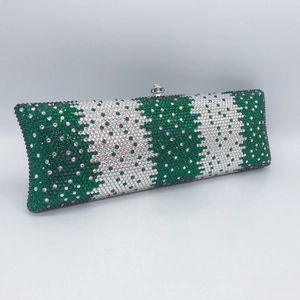 Macro shot of green and white crystal rhinestones on a rectangle evening clutch bag