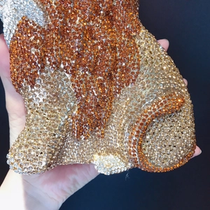 Macro shot of sparkling crystal-encrusted lion evening clutch showing detailed rhinestone texture