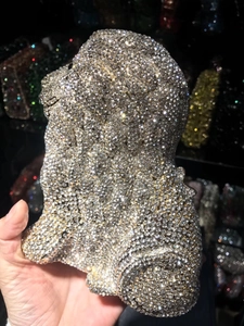 Macro detail of lion-shaped evening bag featuring handset clear rhinestones and gold trim