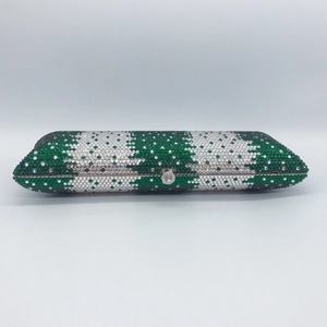 Macro detail of rectangle clutch bag featuring green and silver rhinestone camouflage pattern