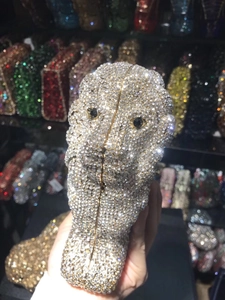 Macro detail of lion-shaped evening clutch featuring dense gold and silver crystal embellishments