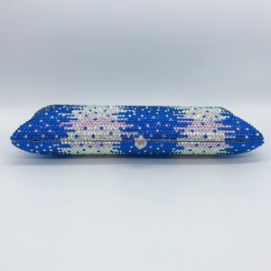 Macro shot of blue and iridescent rhinestone cloud pattern on a hard-shell evening clutch