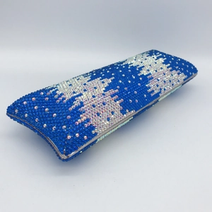 Close-up of sparkling blue and silver rhinestone patterns on luxury evening clutch bag